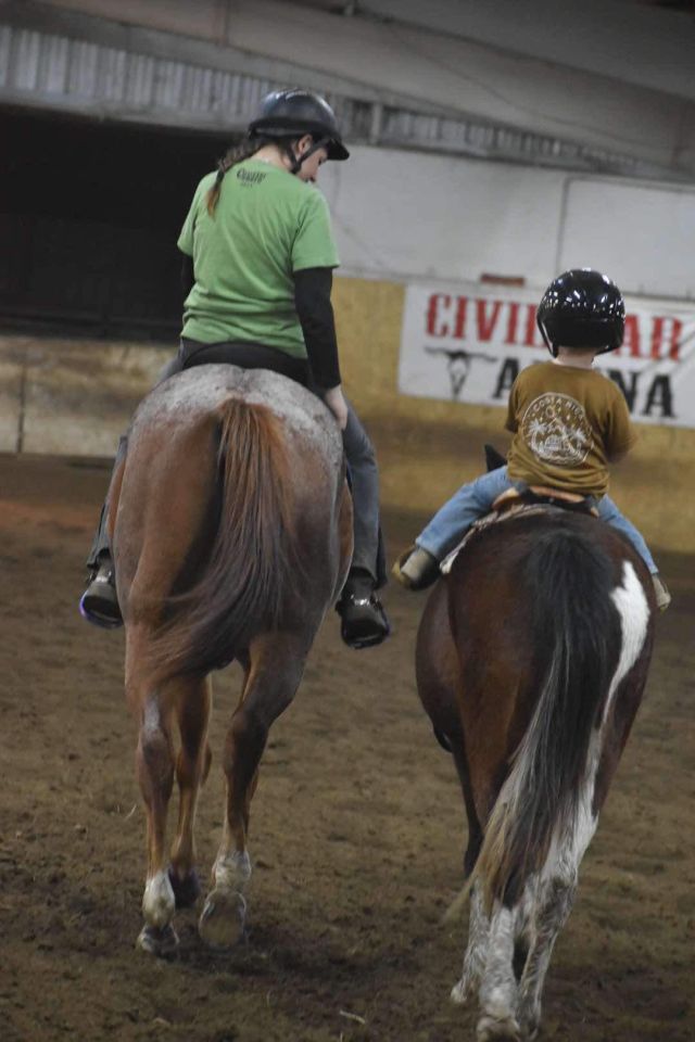 Two children on horses side by side at Civil War Arena